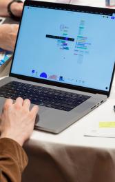 A person at a laptop computer working on an unlimited canvas application with sticky notes